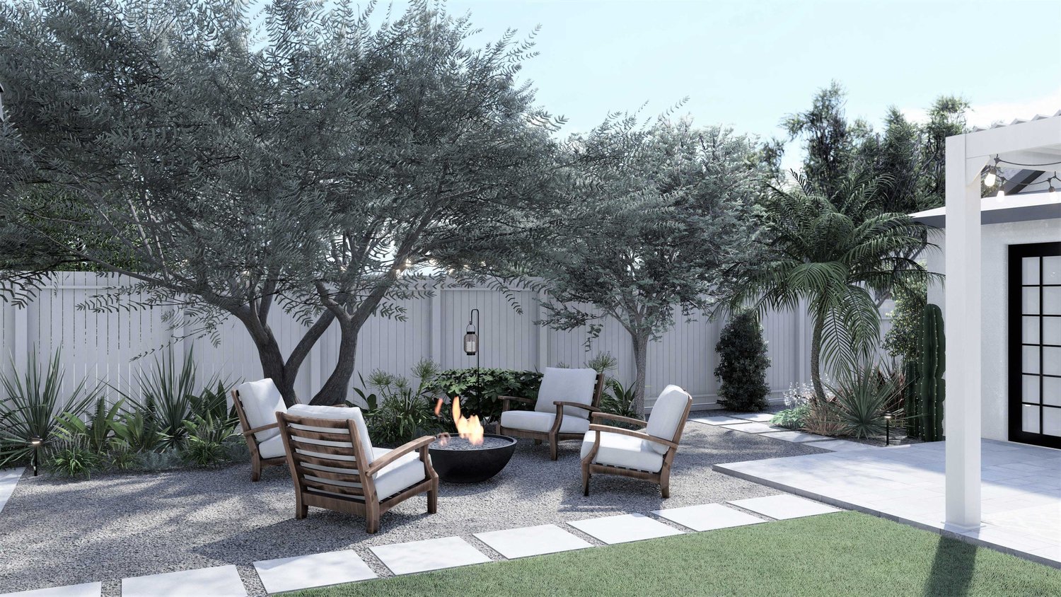 Los Angeles fenced backyard with gravel fire pit seating area with lounge chairs, trees, plants, lawn and paver walkway