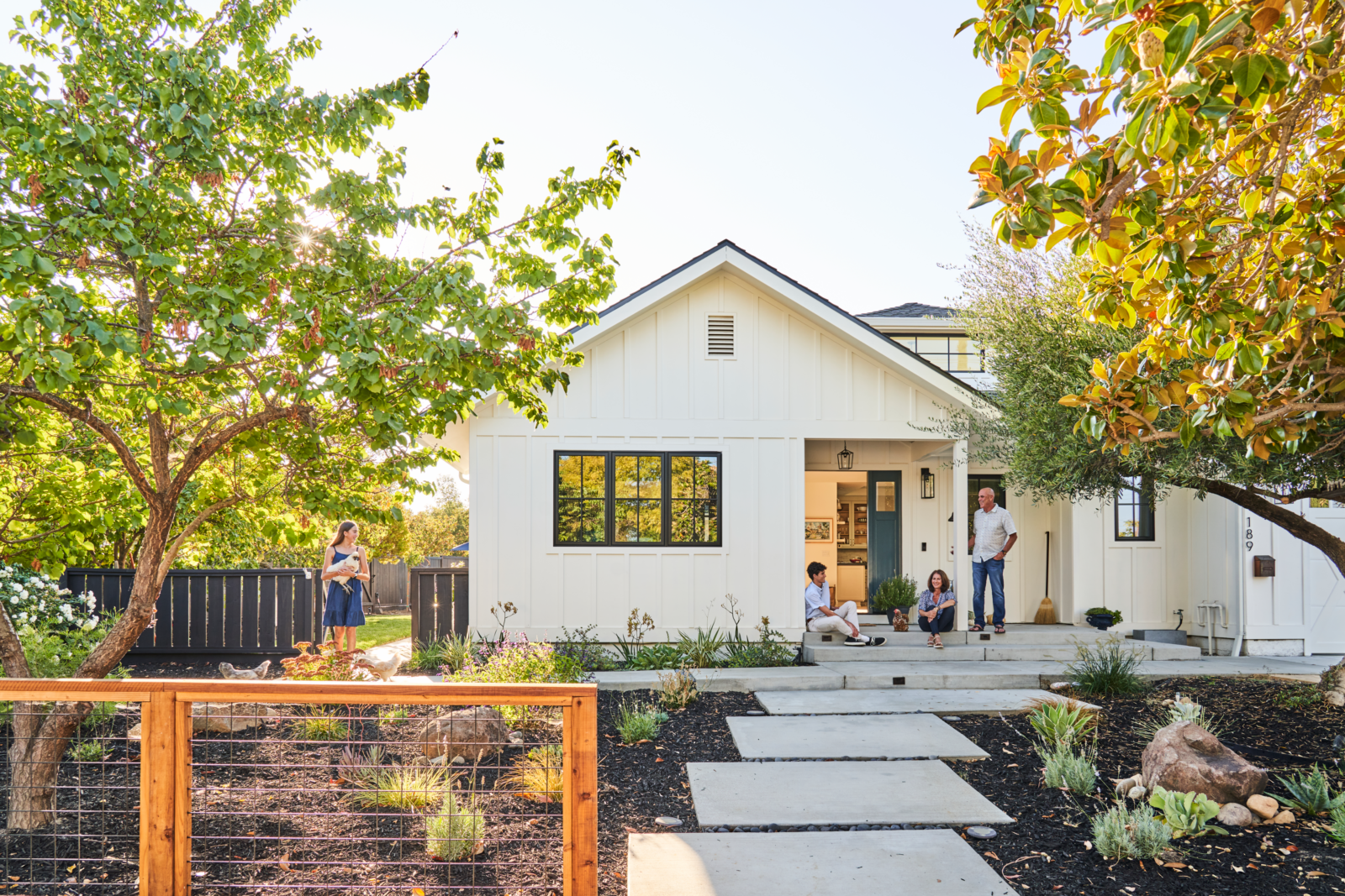 a grass-free front yard with a staggered paver walkway, native plants, and mulch