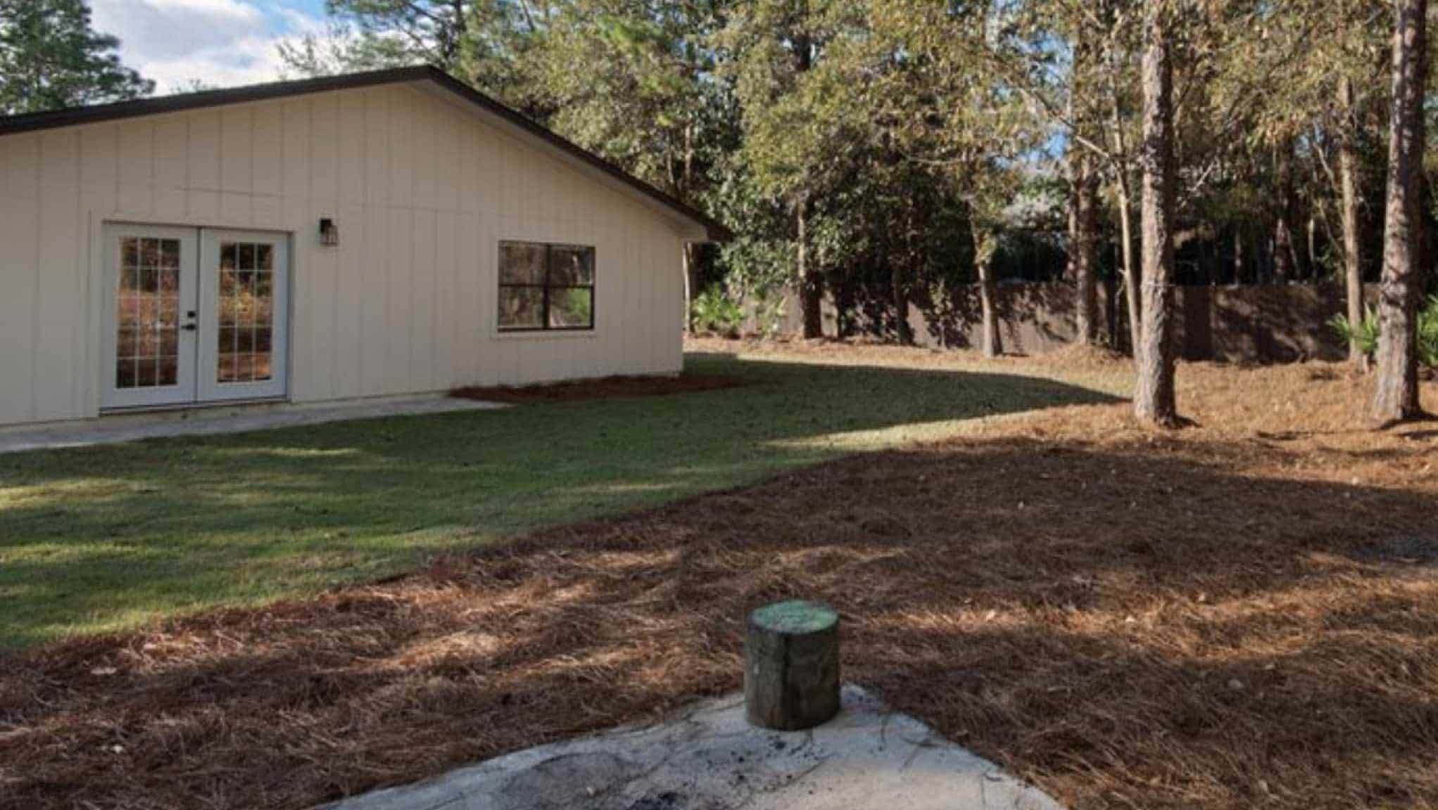 Before photo of yard with large pine-needle covered area with no plants