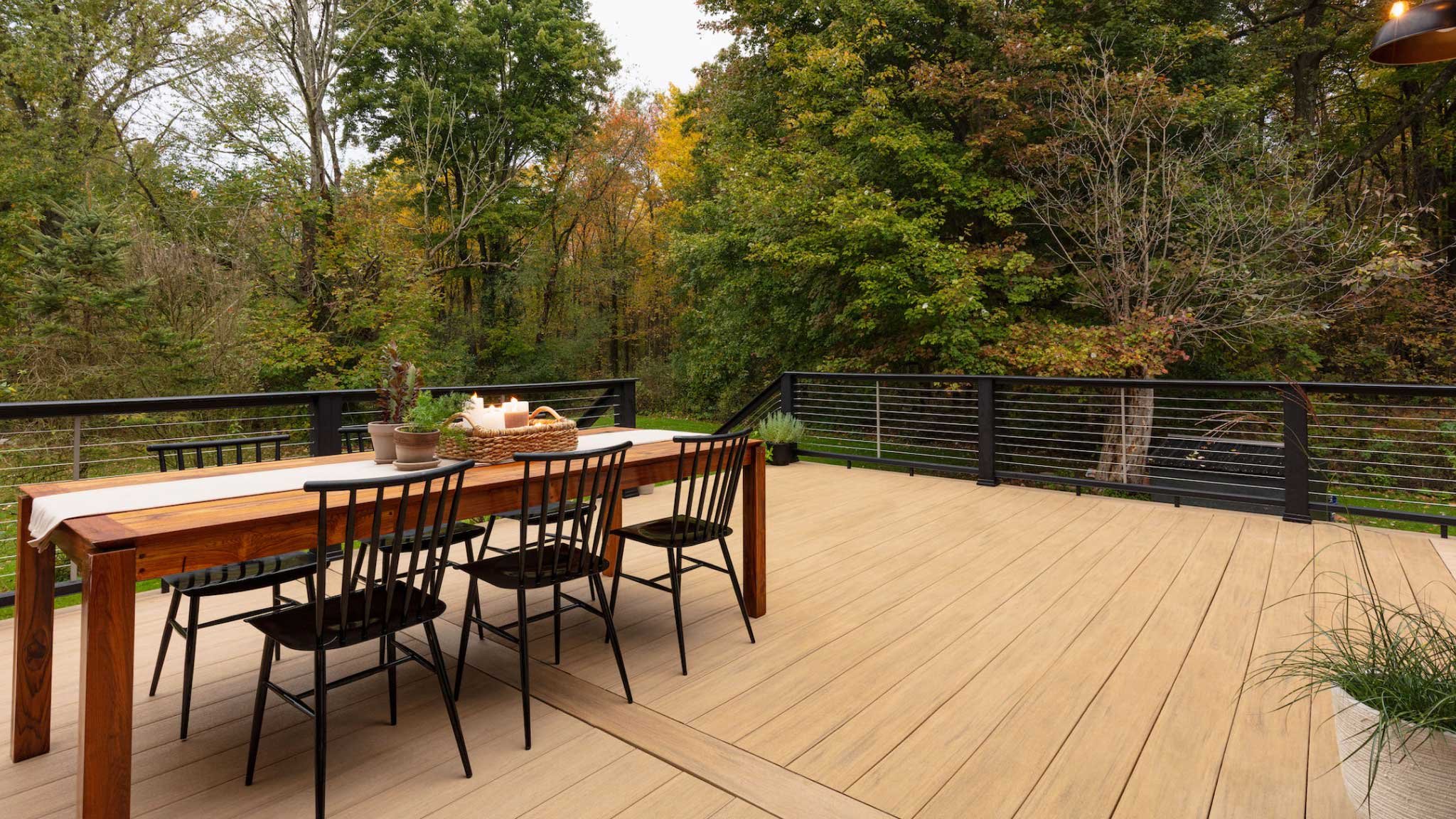 Stylish new deck with outdoor dining set and fall trees in background