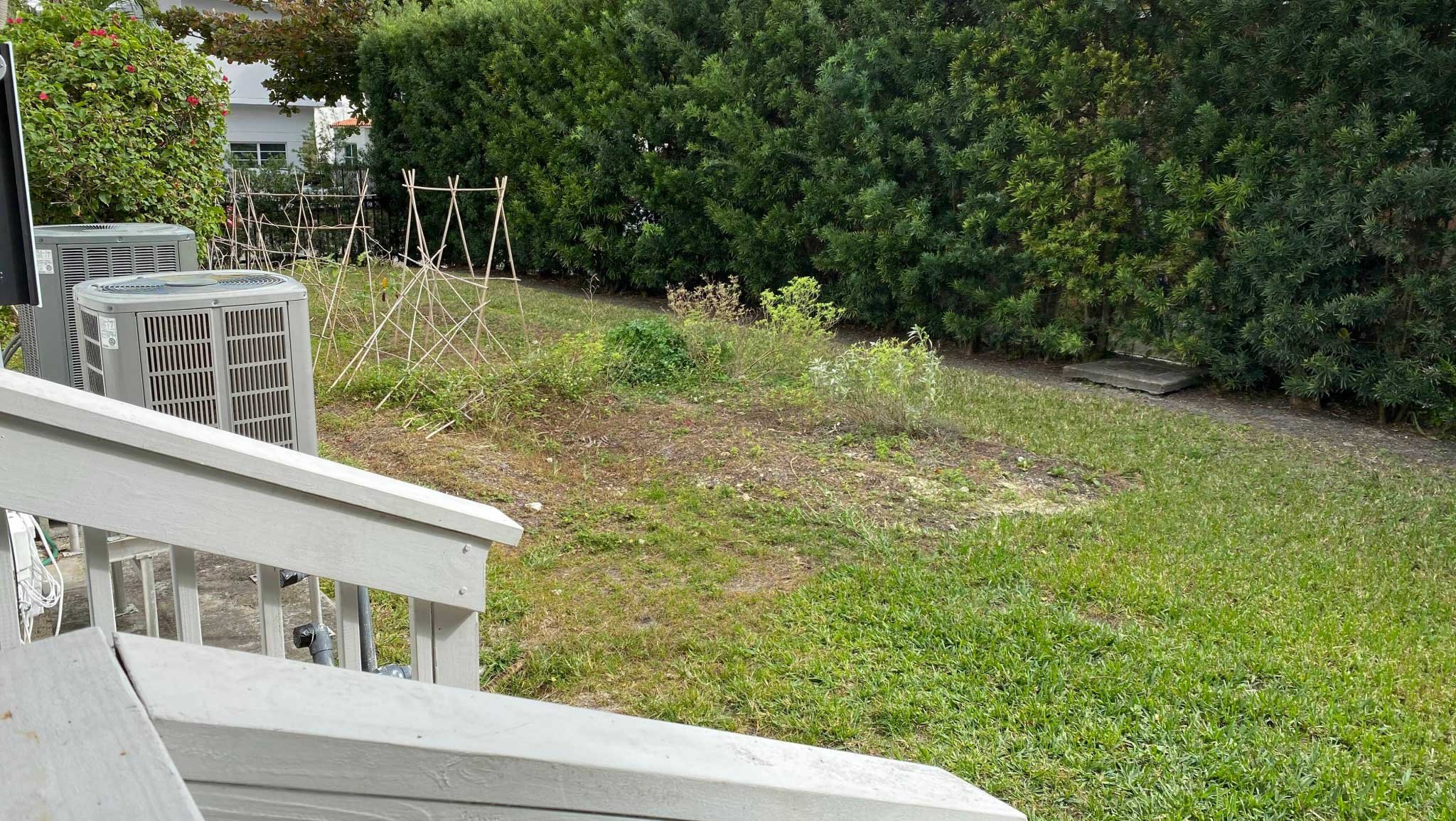 Before photo of yard with struggling lawn and garden area