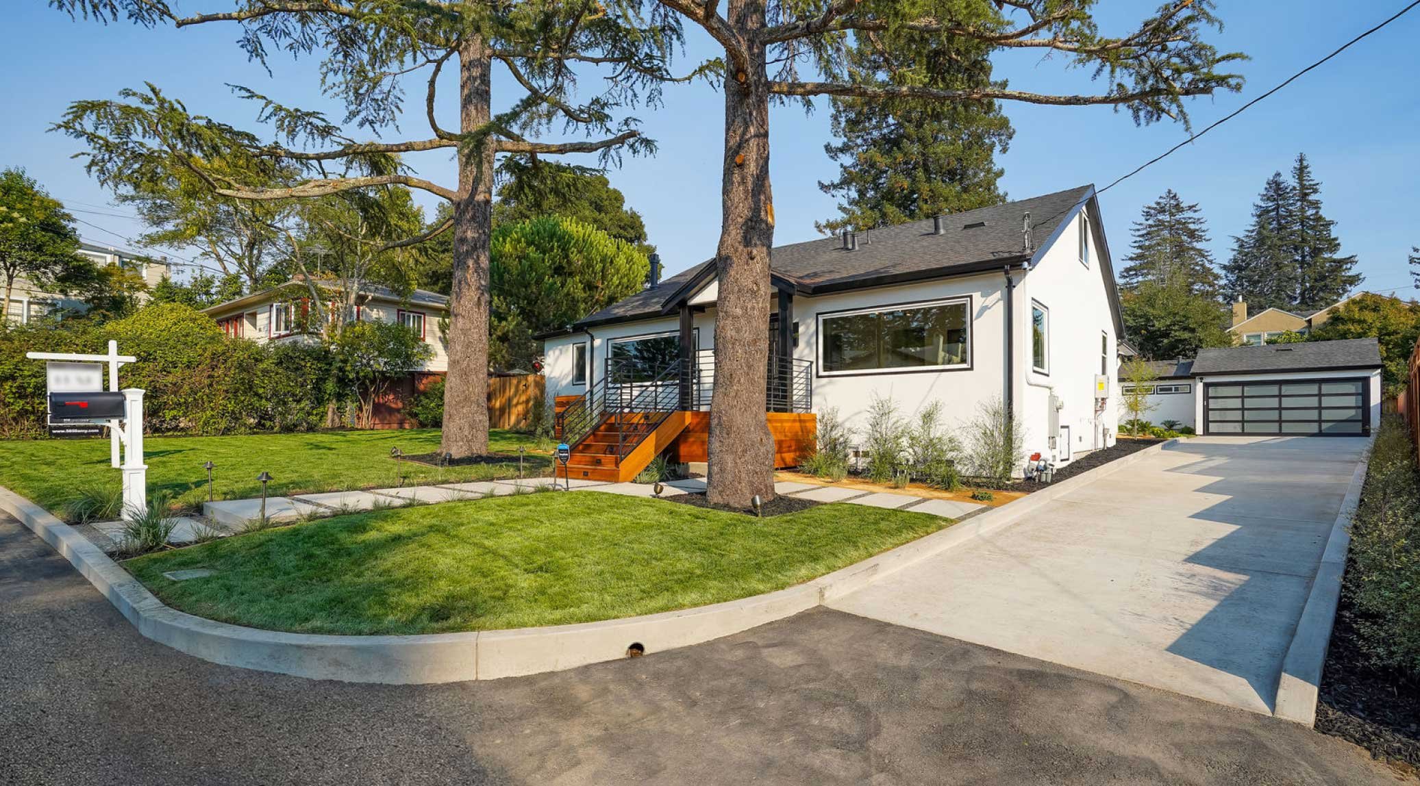 Finished front yard as seen from street with healthy lawn, concrete stepper paths, and modern porch