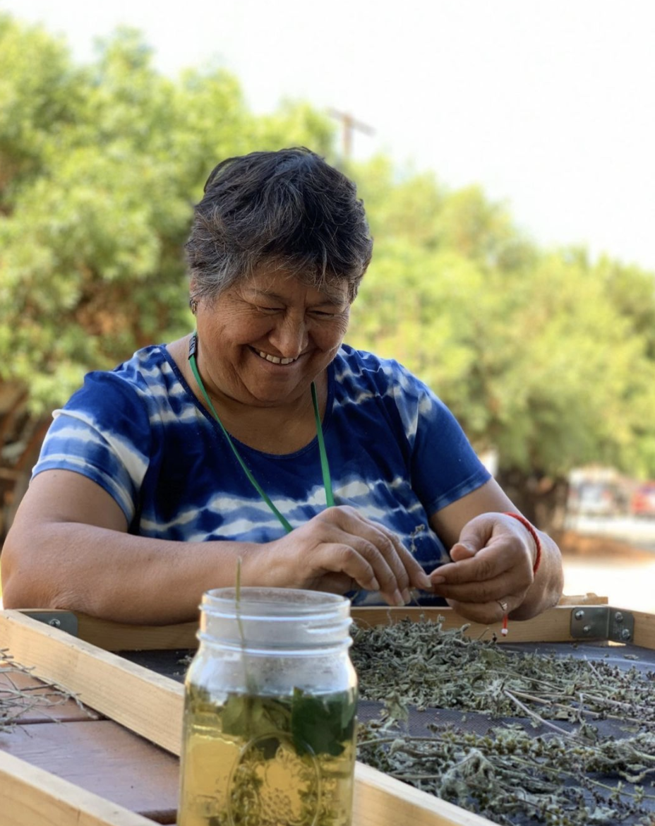 A woman sorting dried medicinal herbs