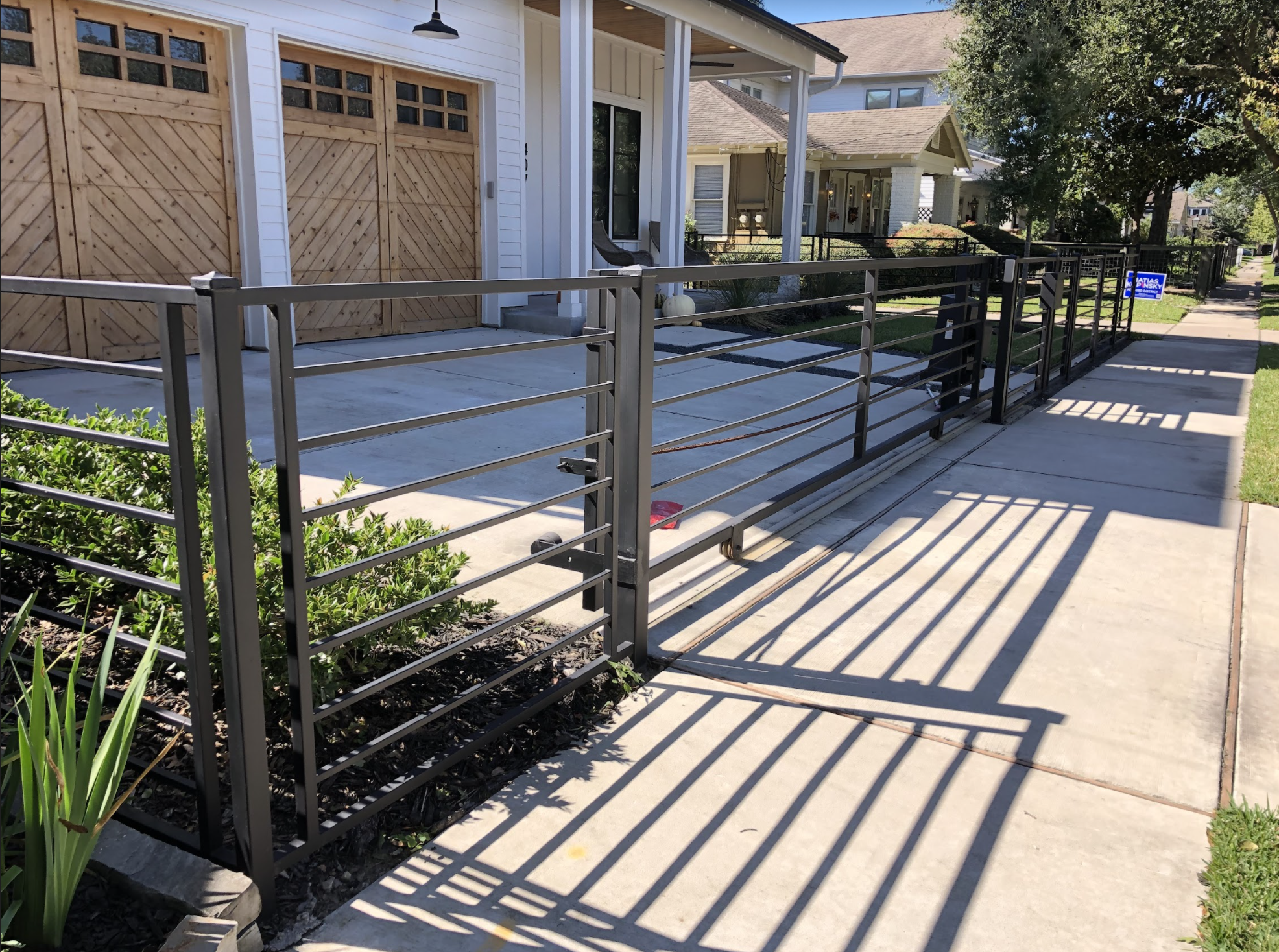 Yard with concrete walkway and hog wire fence surrounding the house