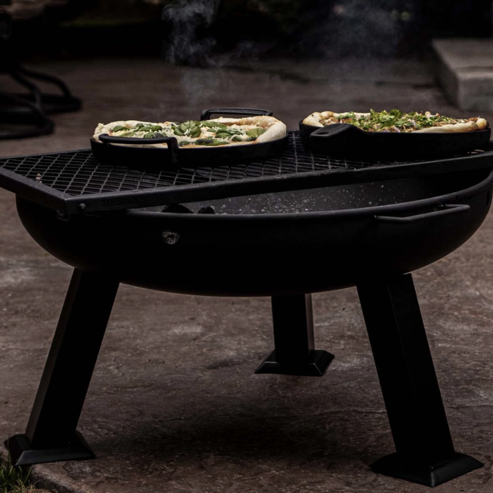 Barebones Living Fire Pit - Barebone’s stainless steel wood burning fire bowl is built for durability but is lighter than cast iron. This makes it the perfect portable fire pit, going effortlessly from a bbq at the campground to warming up in your backyard. But it’s equally cool—with its sleek black finish, solid legs and a pair of handles—all for toasting marshmallows or just getting toasty. SHOP NOW >” loading=”lazy”></noscript><br/><img loading=