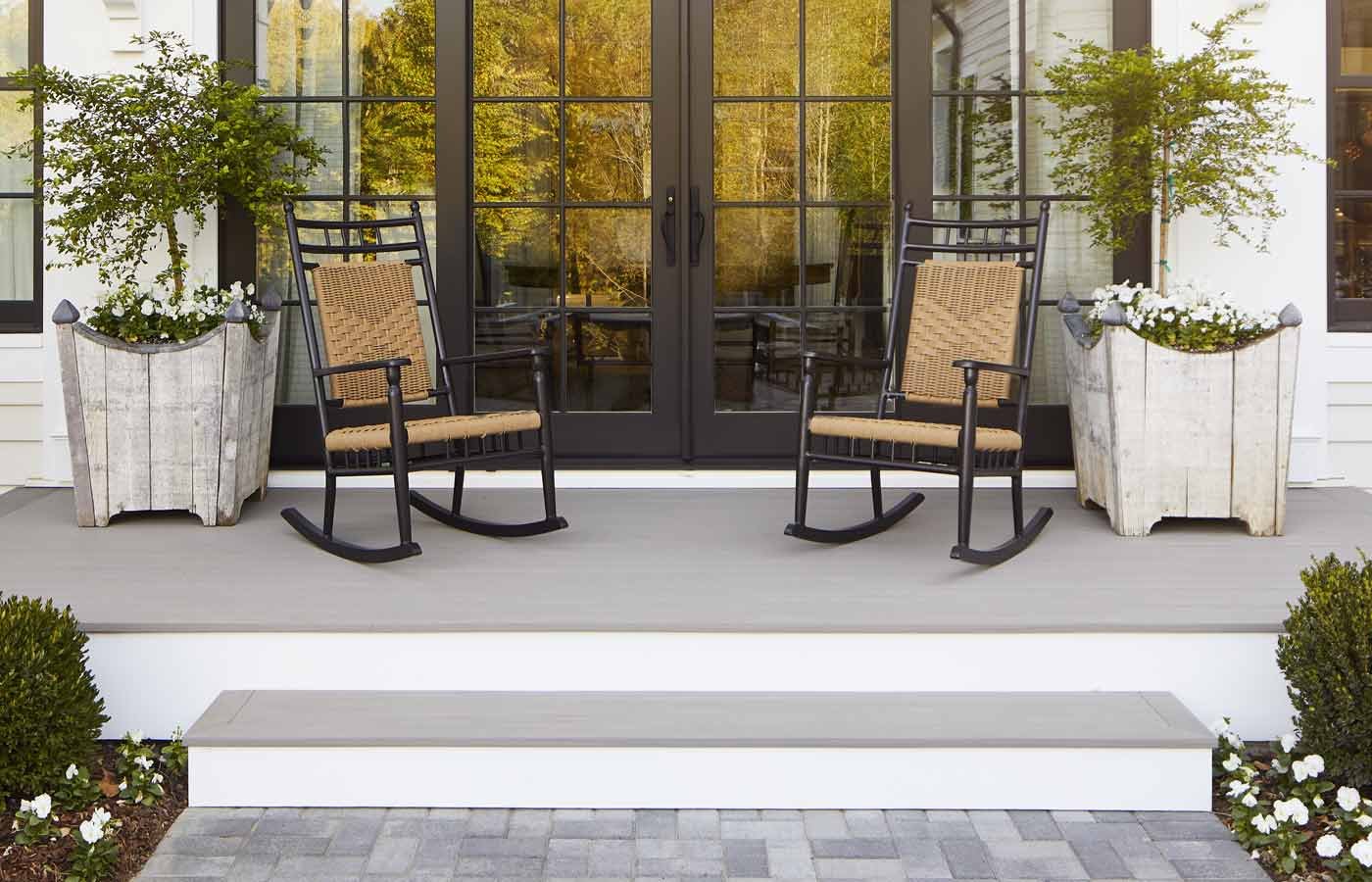 A patio with rocking chairs and potted plants