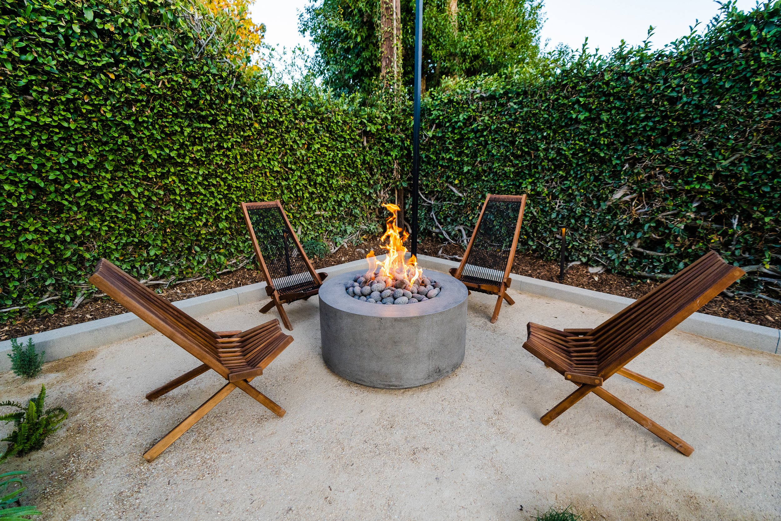 Round concrete fire pit with reclining chairs