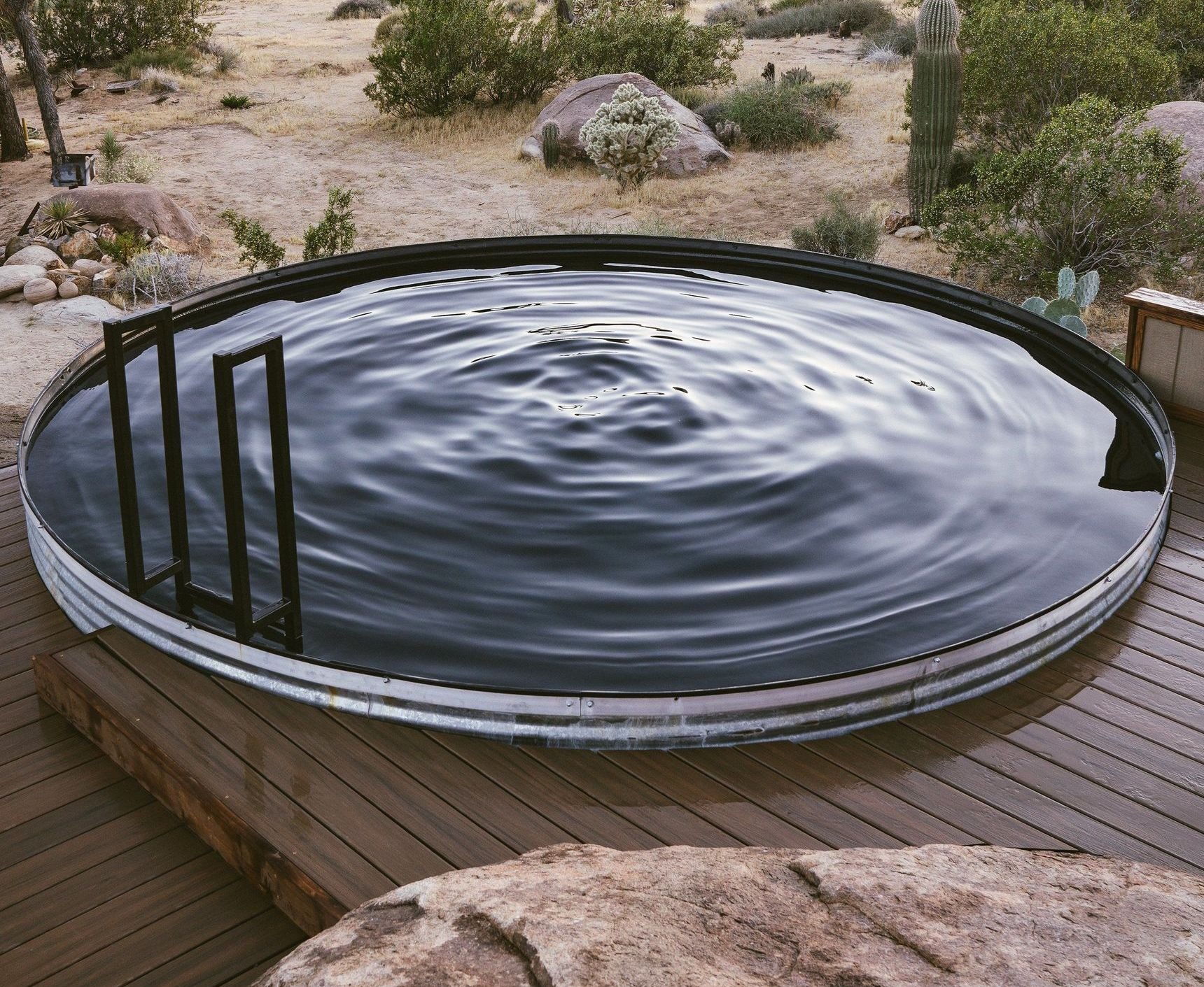 Close-up of tranquil rippling water in a stock tank pool surrounded by a desert landscape.