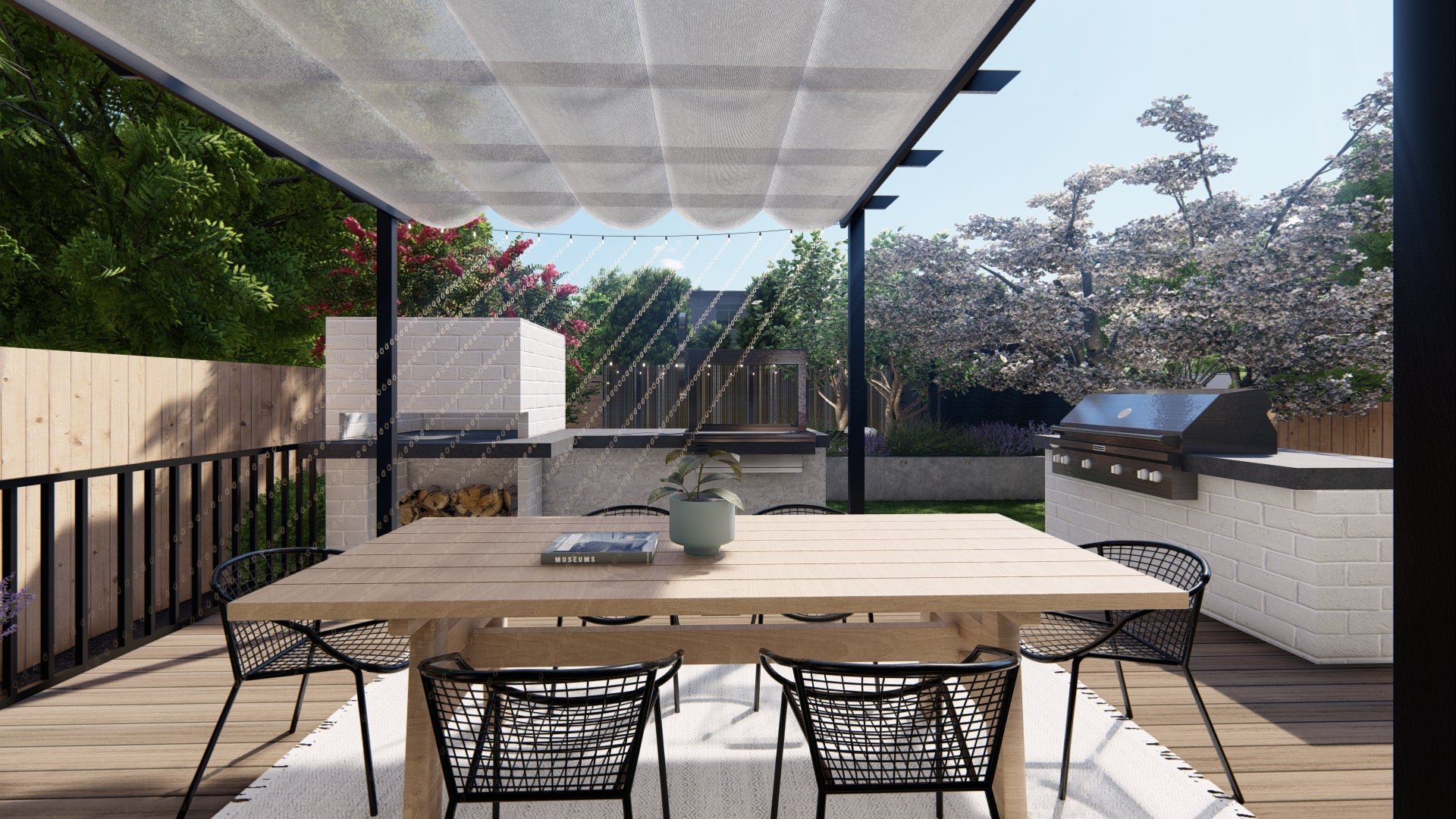 RH’s Merida teak dining table looks looks great paired with a white brick outdoor kitchen and black metal chairs in this backyard design for our client in Seattle, WA.
