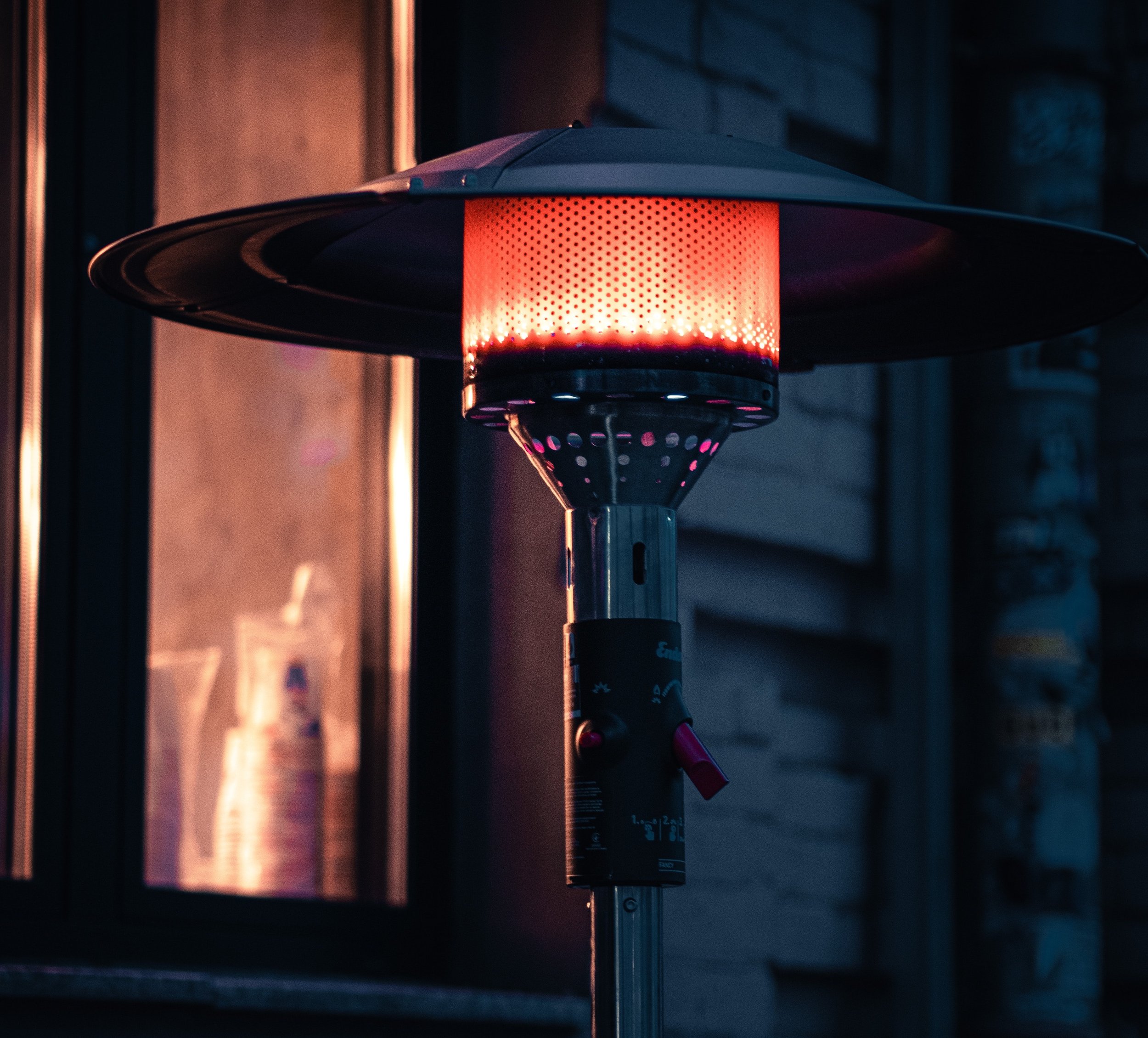 Close up of glowing outdoor heat lamp outdoors at night