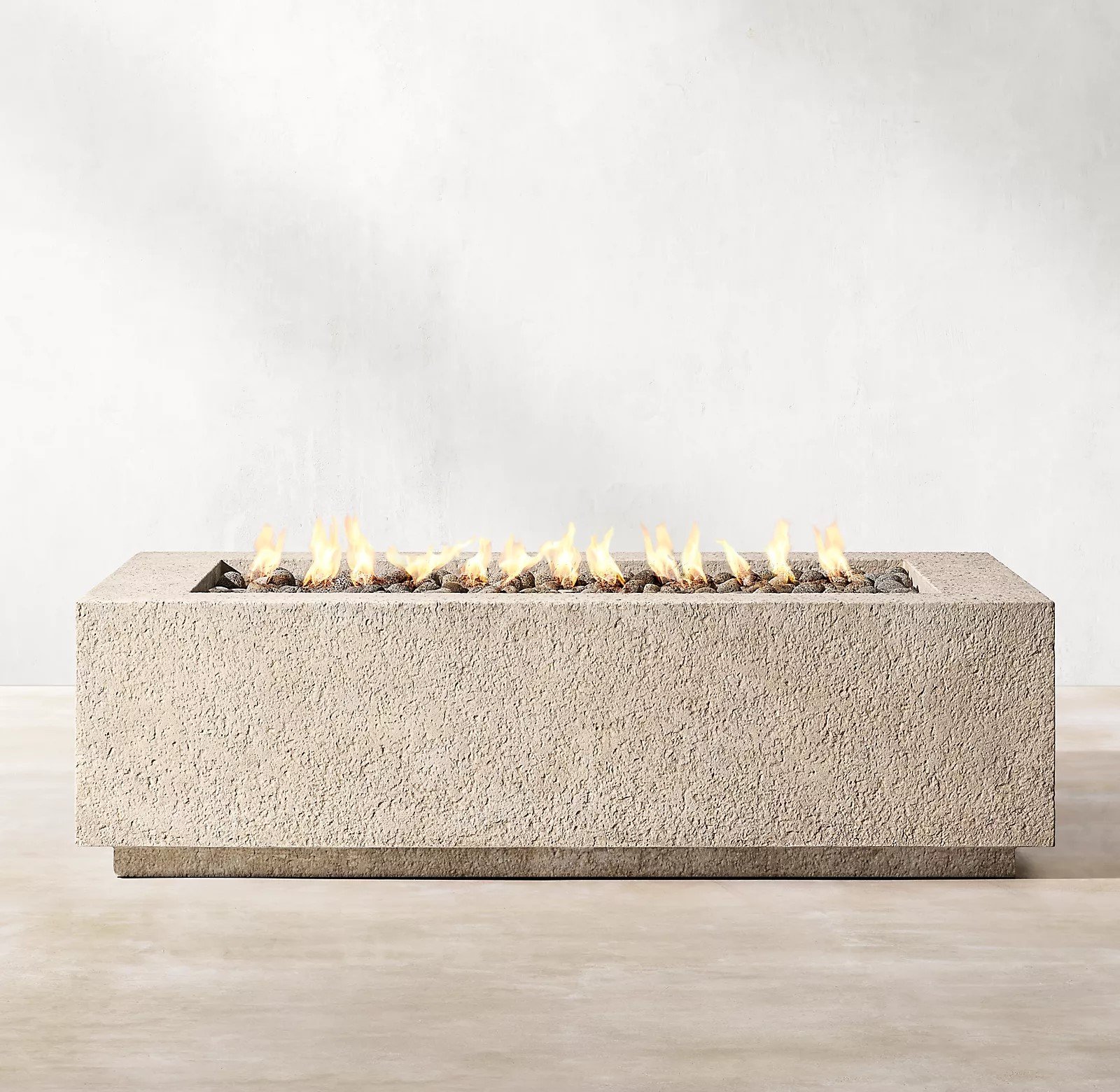 RH’s Yountville Rectangular Fire Table - Pairing minimalist geometry with rustic, hand-hewn texture, the Yountville gas fire pit table offers a bold, elemental presence outdoors. Masterfully crafted of concrete composite for the look of weathered stone with natural lava rock, it is a durable, lighter-weight alternative to pure concrete or stone, and is rated at 65,000 BTUs.SHOP NOW >” loading=”lazy”></noscript><br/><img decoding=