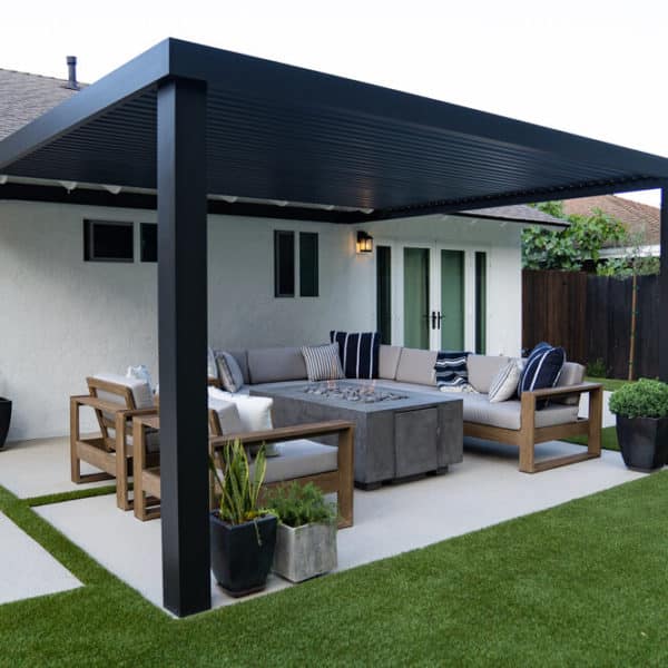 Modern backyard with black pergola off back of home shading a fire pit seating area