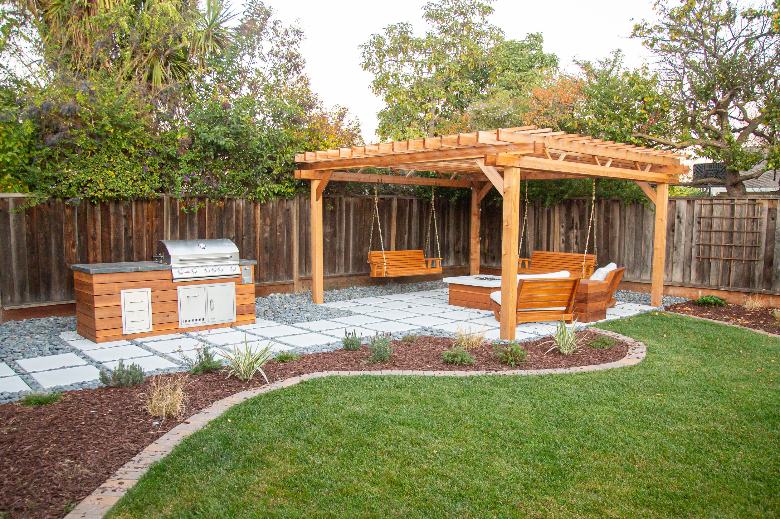traditional wooden pergola on concrete paver patio with handing bench swings and fire pit