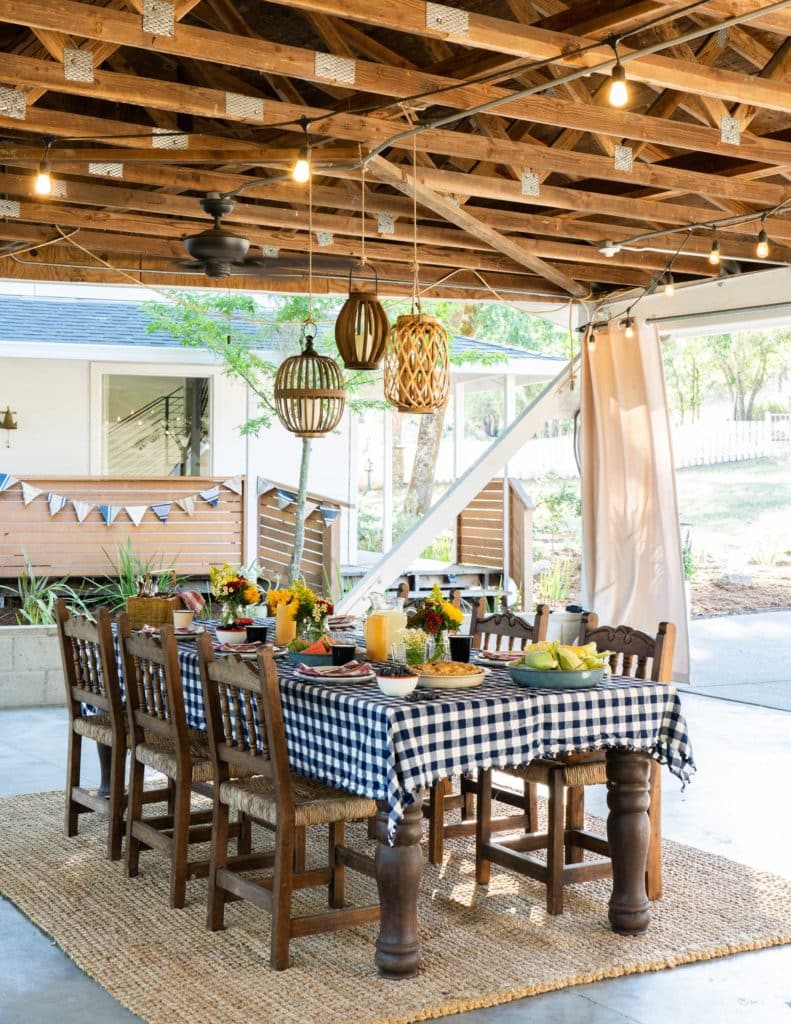 A pergola with hanging lights over a dining set