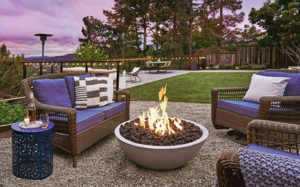 Fire pit area with lounge chairs in sloped backyard for Yardzen client
