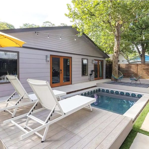 Small backyard with tiled plunge pool and pool deck with lounge chairs