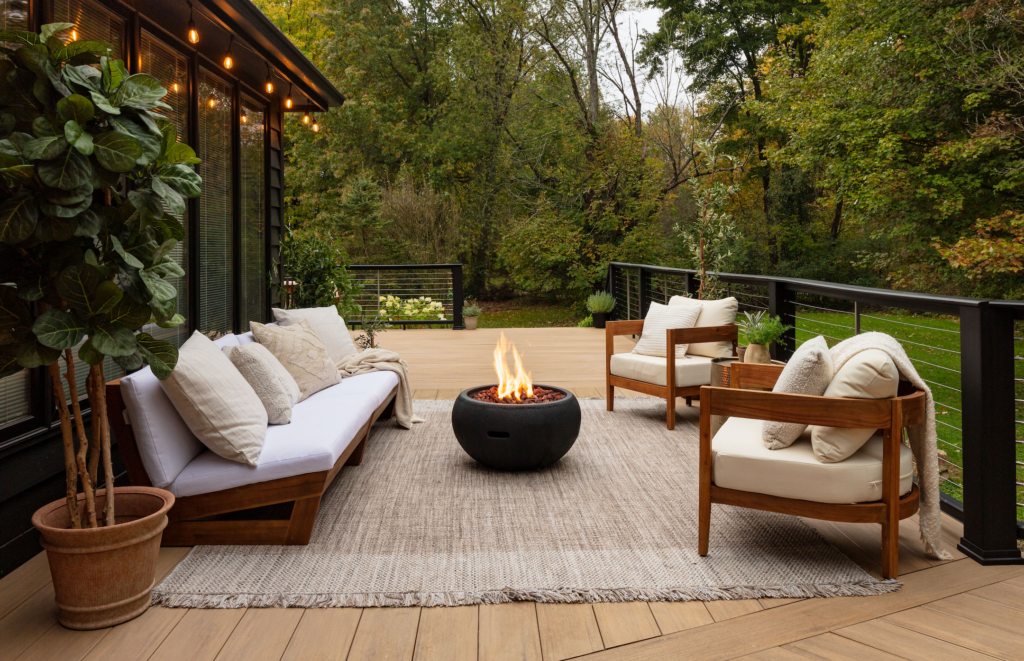 TimberTech deck with modern fire pit and outdoor lounge area in a Yardzen yard