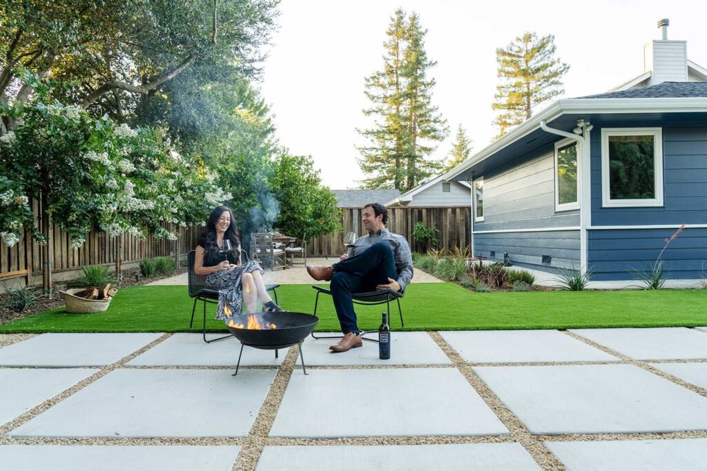 Couple enjoys wine near outdoor fire pit in their Yardzen-designed backyard in Napa, CA 
