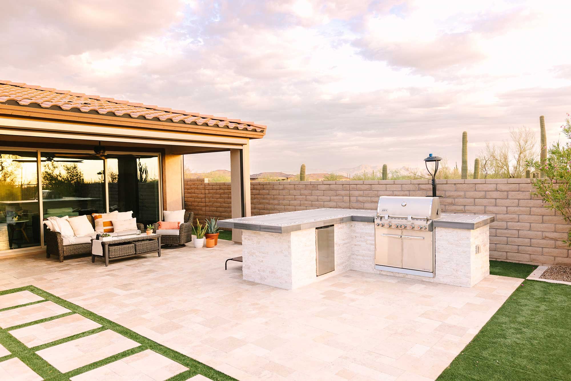 A single pad of travertine paving creates a seamless relationship between the kitchen and covered patio.