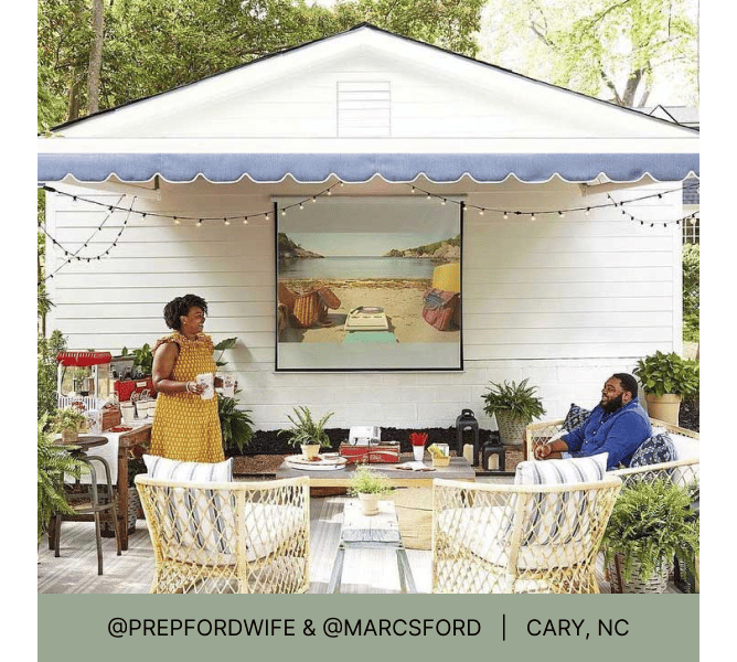 Couple enjoying a shaded patio while watching a movie on an outdoor projector and heading that reads @prepfordwife & @marcsford Cary, NC