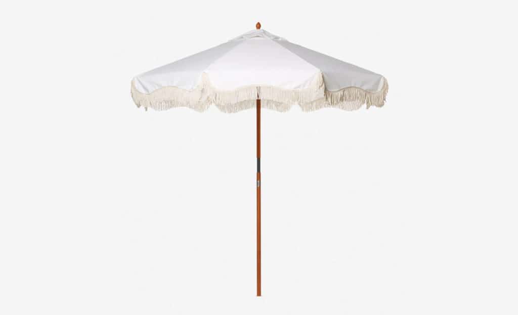 white modern bohemian outdoor umbrella with fringe and wooden pole