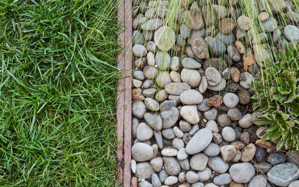 Landscaping detail with grass, river rocks and landscape edging