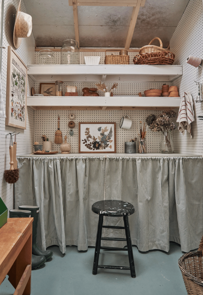 Shed interior with workbench, stool, shelving, and pegboard for organization