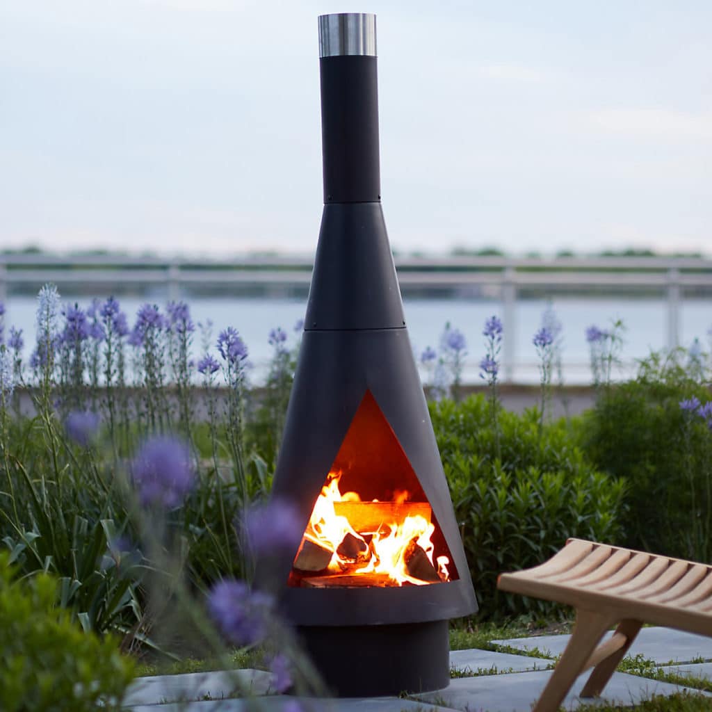 Black modern chiminea lit with flame