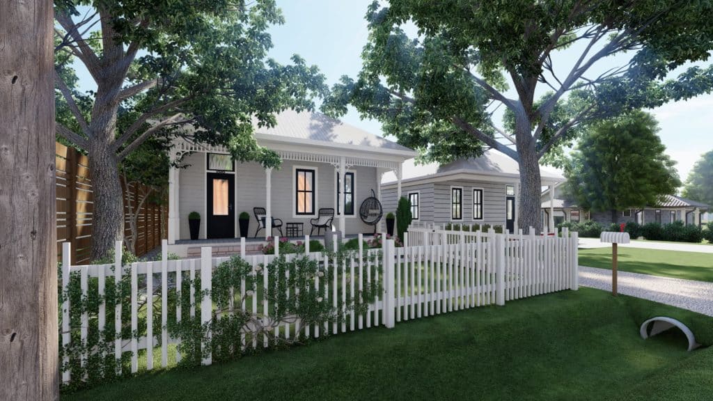 gingerbread style porch and lawned front yard contained by a white vinyl horizontal post fence