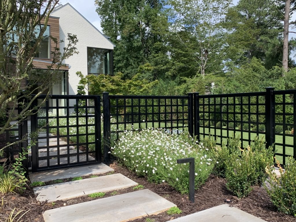 Front yard with paver path and black metal fence