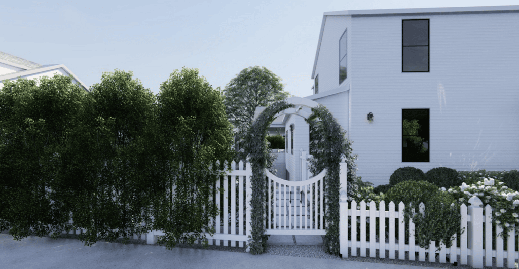 White home with white picket front yard fence and arbor to front walkway covered in vines.