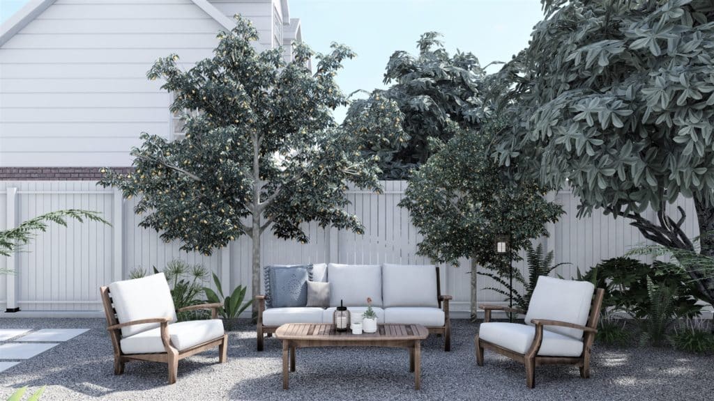 Backyard seating area with white-cushioned sofa and lounge chairs and coffee table on gravel
