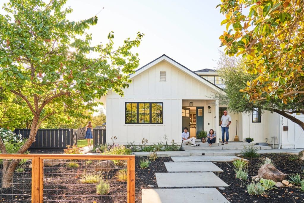 Modern farmhouse style home with large concrete paver front path and mulched planting areas with drought tolerant plants and trees