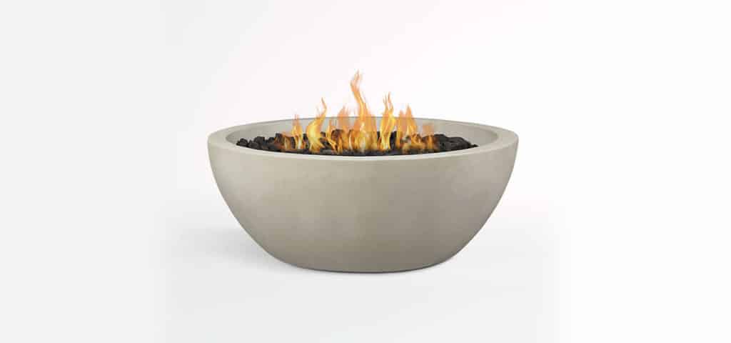 concrete fire bowl with black decorative rock lit with flame