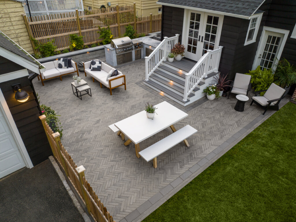 an angled, high-up view of the client's newly installed back patio area. The herringbone patio and layout closely match the 3D render.