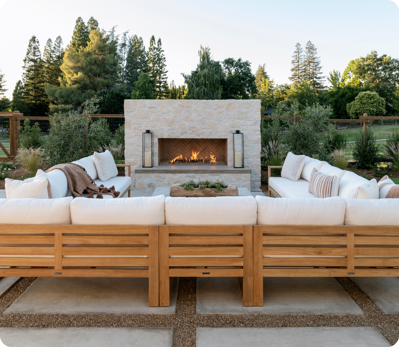 Outdoor fireplace with large sectional in golden hour.