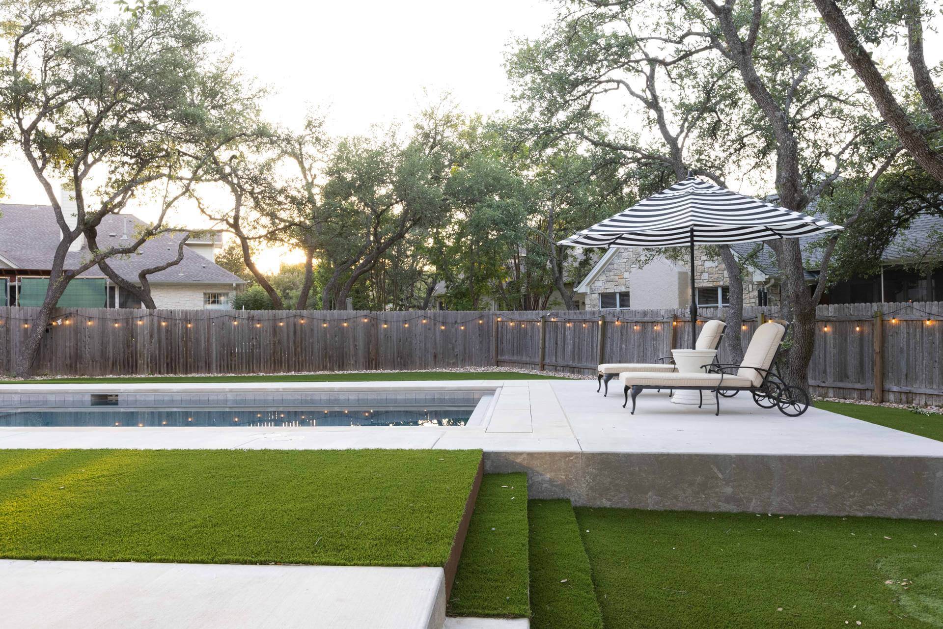 Backyard with artificial turf near swimming pool