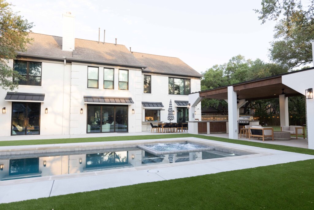 traditional white brick home with pool and covered kitchen