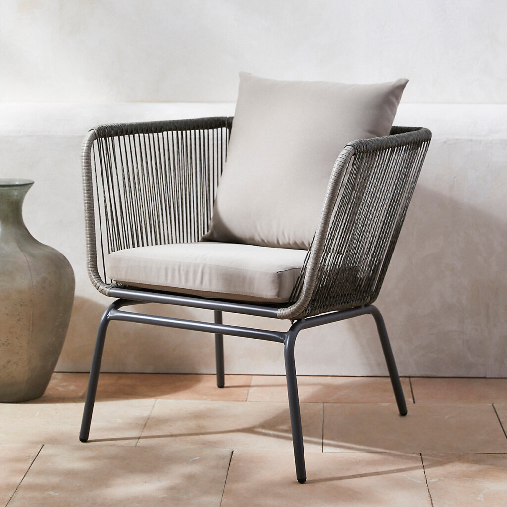 Outdoor chair with light grey cushions and woven frame