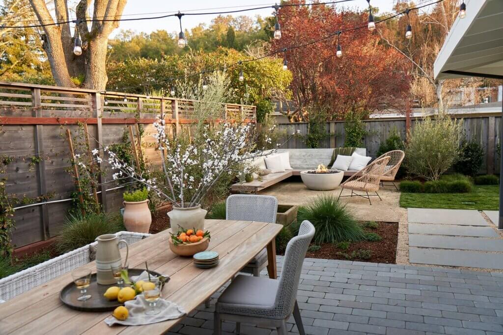 Backyard with outdoor dining area and built in seating around fire pit