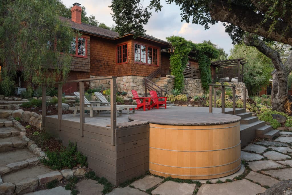 Backyard with wooden hot tub and deck with lounge chairs