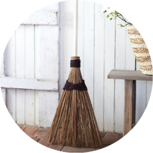 Garden bristle broom leaning against a white wall.