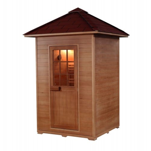 Traditional outdoor sauna with square frame, shingled roof, and wooden door with glass paned window.
