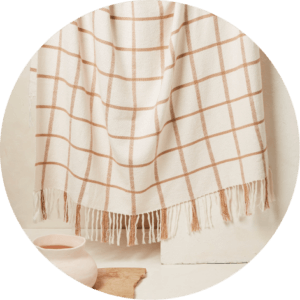 Throw blanket with white and orange checkers and tassels draped.
