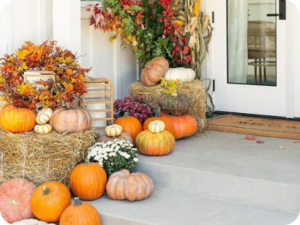 Pumpkins, dried florals and hay bails on a front stoop.