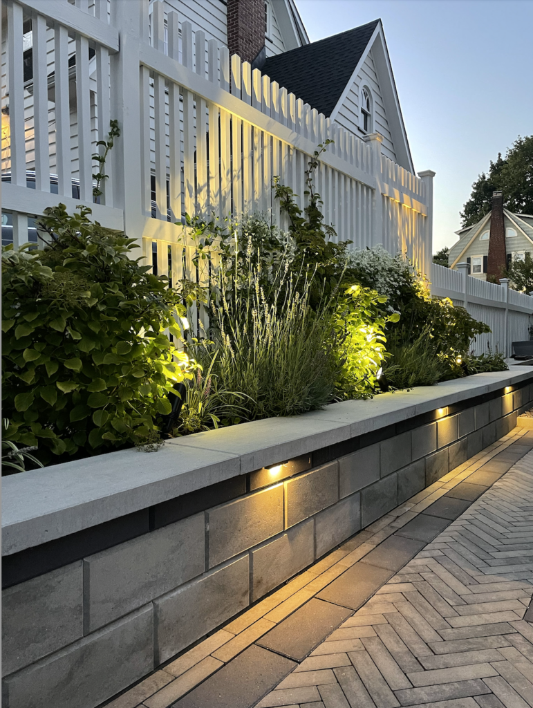 A narrow elevated garden bed, light for dusk