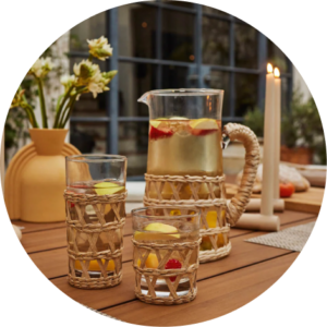 Glass tumblers with woven rope on top with peach tea inside.
