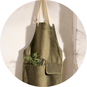 Green garden apron with plants and scissors in the pocket
