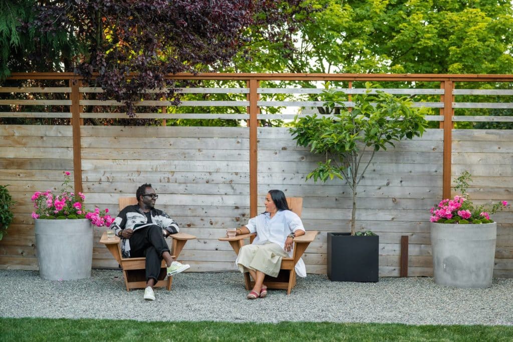 Couple seated in chairs in backyard