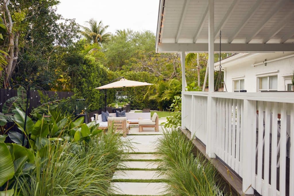 Pathway with tropical plantings leading to backyard seating area